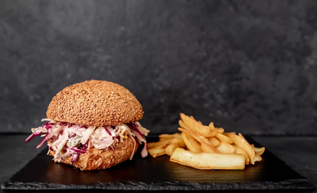 Photo oxtail burger with cabbage fries on a stone table