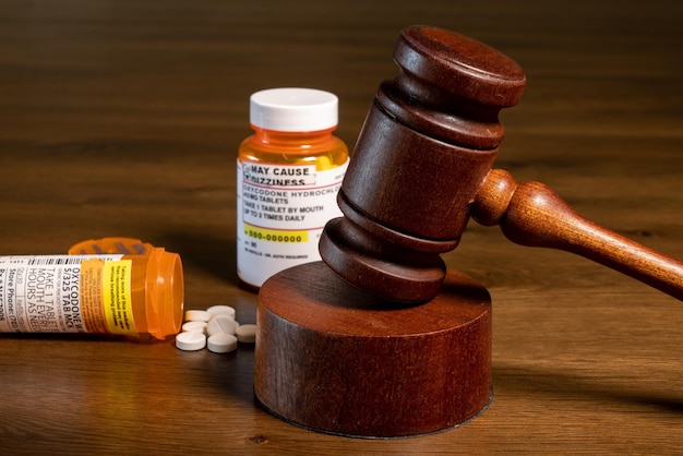 Oxycodone is the generic name for opoid pain killing tablets Prescription bottle for pills and tablets with judge's gavel for court decision