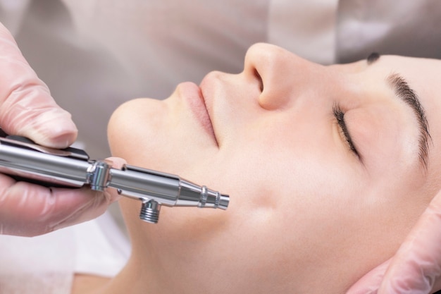 Oxygen mesotherapy. Aquapilling. Cosmetic peeling procedure. Non-injection mesotherapy for a young girl in a beauty salon.