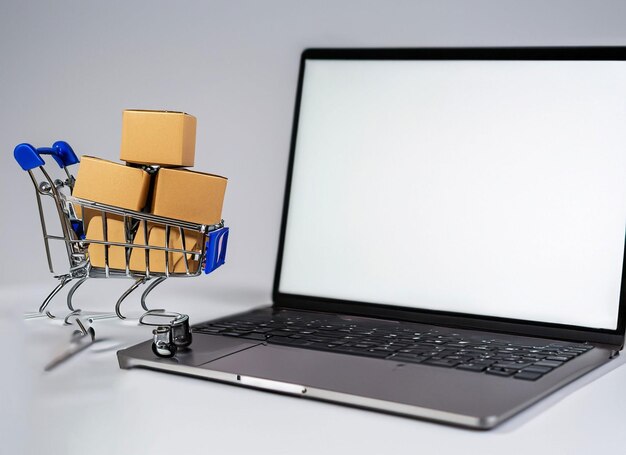 Oy shopping cart with small carton boxes on laptop with blank screen isolated on whit background