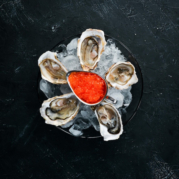 Ostriche e caviale rosso in un piatto di ghiaccio e limone frutti di mare vista dall'alto spazio libero per la copia