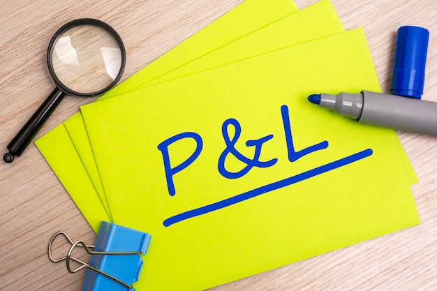 P and L profit and loss acronym text concept with marker on yellow business card