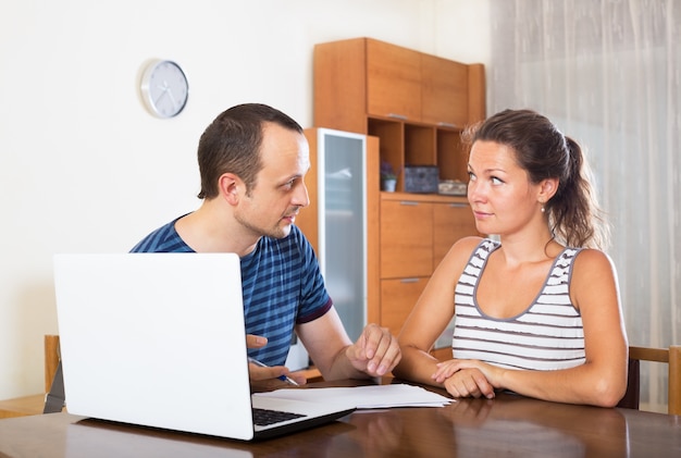 Paar aan een bureau met papieren en laptop