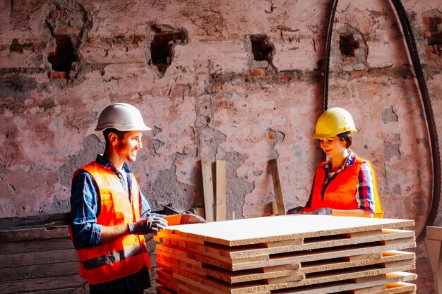 Paar aantrekkelijke werknemers binnenshuis houtbewerkingswerkflore