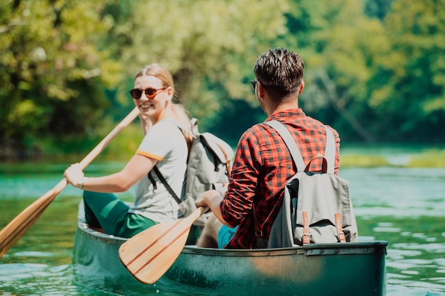 Paar avontuurlijke ontdekkingsreizigersvrienden kunnen kanoën in een wilde rivier omringd door de prachtige natuur.