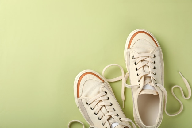 Paar beige sneakers op groene achtergrond