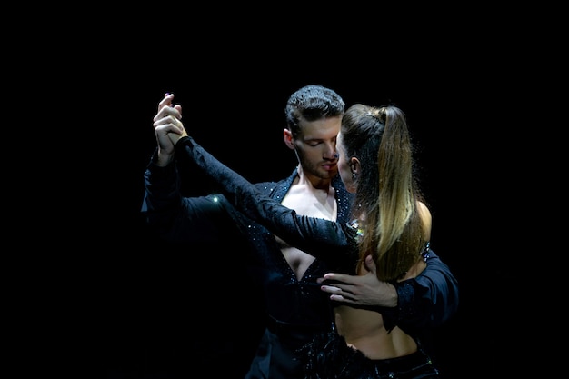 Paar dansers die op geïsoleerde zwarte presteren. Gespierde knappe man en aantrekkelijke vrouw