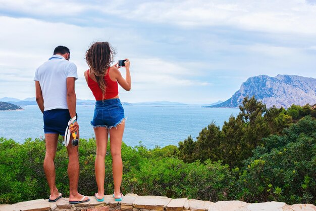 Paar dat foto's neemt van het eiland Tavolaro in Capo Coda Covallo, San Teodoro in de provincie Olbia-Tempio, Sardinië, Italië