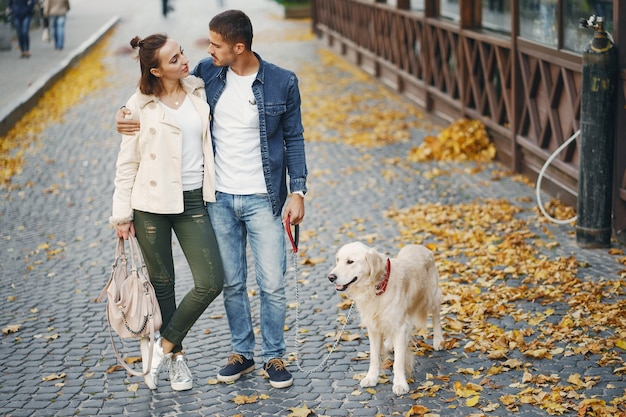 paar dat hun hond op een zonnige de herfstdag loopt