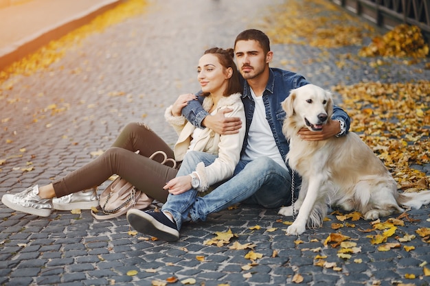 paar dat hun hond op een zonnige de herfstdag loopt