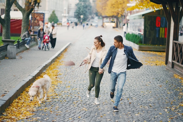 paar dat hun hond op een zonnige de herfstdag loopt