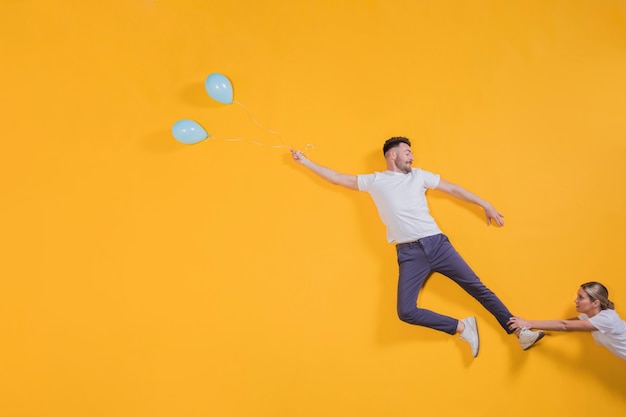 Paar dat in de lucht met ballons drijft