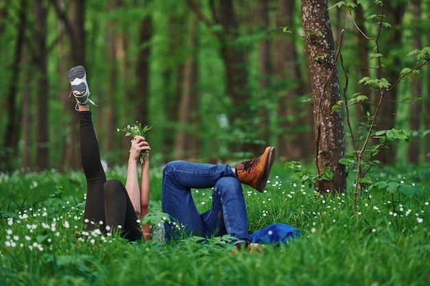 Paar dat overdag samen op het gras in het bos ligt