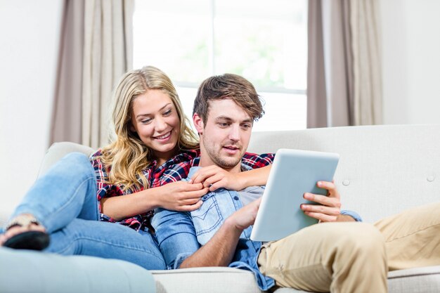 Paar dat tabletcomputer op de bank met behulp van