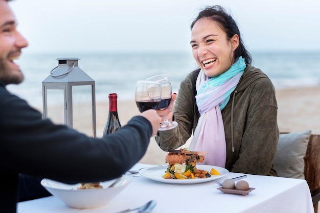 Paar dat van een romantisch diner geniet bij het strand