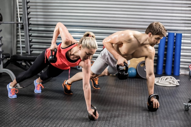 Paar die duw met domoren doen bij crossfitgymnastiek