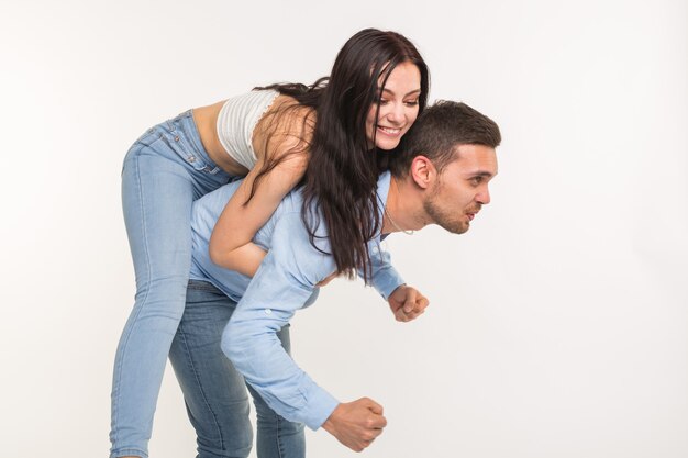 Paar die zich voordeed op witte achtergrond - man met vrouw op zijn rug.