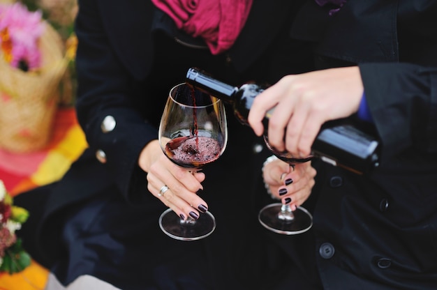 Paar drinken van rode wijn buiten op een picknick