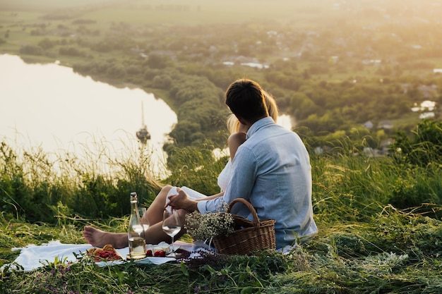 paar geniet van picknicktijd bij zonsondergang