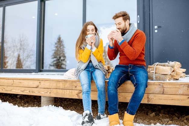 Paar genieten van de natuur in de buurt van het huis tijdens de winter in de bergen