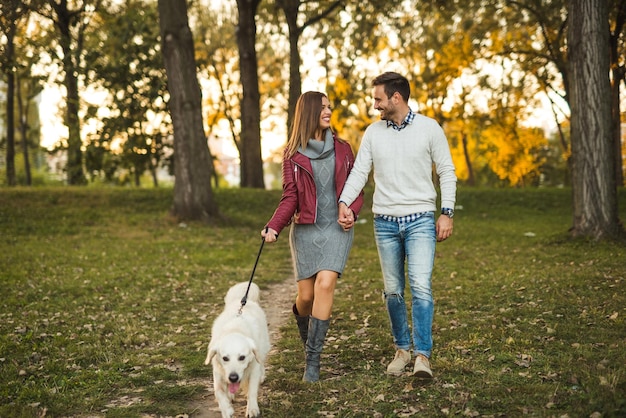 Paar genieten van wandelen met een hond in het park