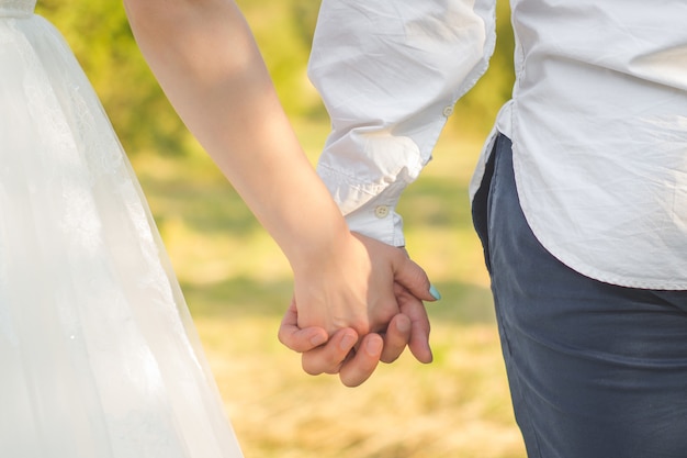 Paar hand in hand tijdens hun wandeling Close-up op handen van man en vrouw in zonnige zomerdag