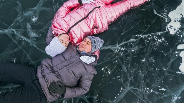 Paar heeft plezier tijdens winterwandeling tegen de achtergrond van ijs van f