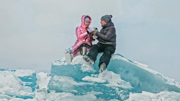 Paar heeft plezier tijdens winterwandeling tegen de achtergrond van ijs van f