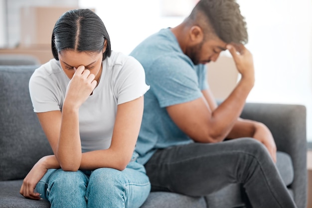 Foto paar huwelijksruzie en vrouw verdrietig en depressief voelen op de bank in de woonkamer met relatieprobleem echtscheiding praten bedrog angst en crisis van jonge mensen op een lounge bank thuis denken