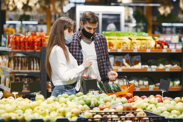 Paar in medische beschermend masker in een supermarkt.