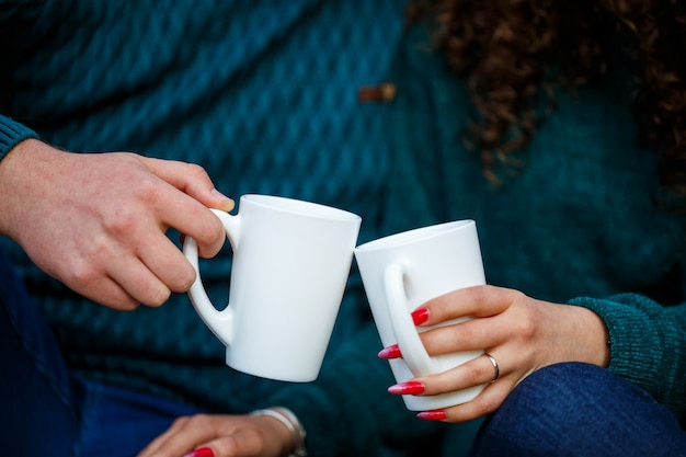 Paar in truien drinkt thee in het herfstbos