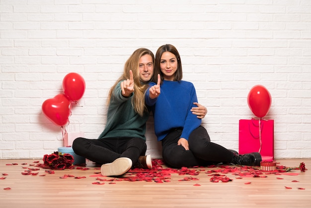 Paar in valentijnskaartdag die en een vinger toont opheft