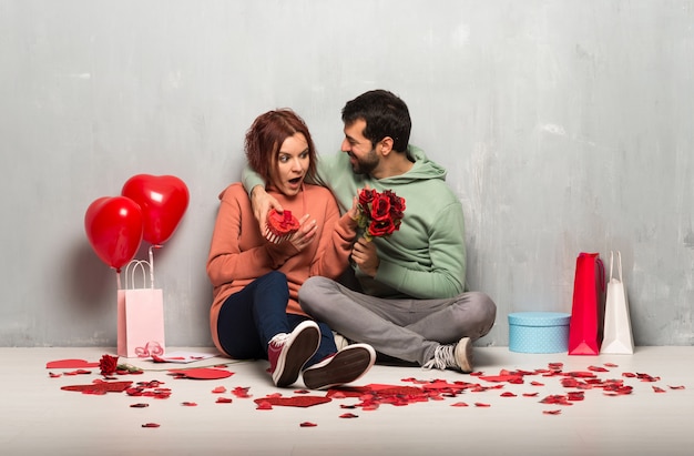 Paar in valentijnskaartdag met bloemen en giften