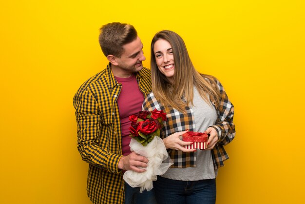 Paar in valentijnskaartdag met bloemen en giften