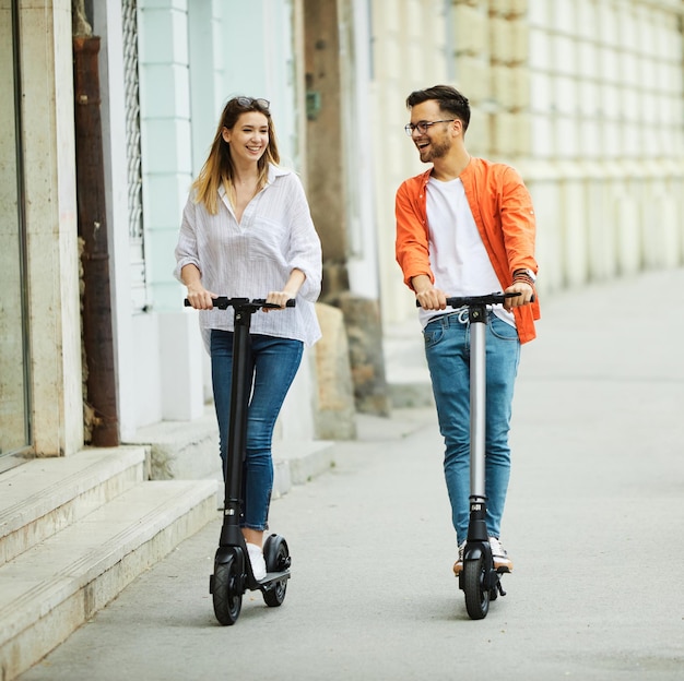 Paar jonge elektrische scooter stadsvervoer rijden technologie levensstijl straatvriend modern rijden