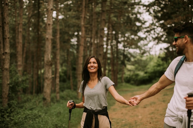 Paar jonge wandelaars met rugzakken lopen door het bos