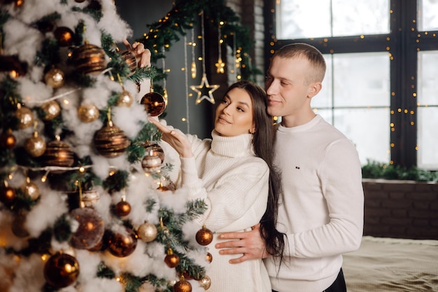 Paar kerstboom versieren met stertopper in kamer