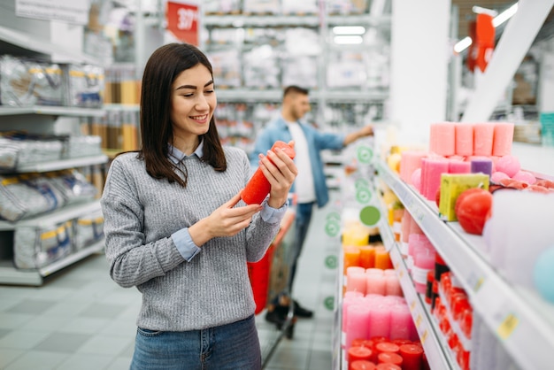 Paar kiezen kaarsen in supermarkt, familie winkelen. Klanten in de winkel, kopers in de markt