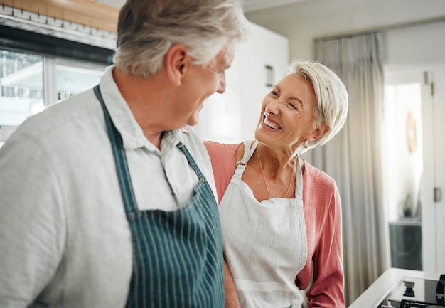Paar koken en liefhebben met een senior man en vrouw in de keuken om eten of een maaltijd thuis te bereiden Pensioen blij en glimlach met een oudere mannelijke en vrouwelijke gepensioneerde samen in hun huis