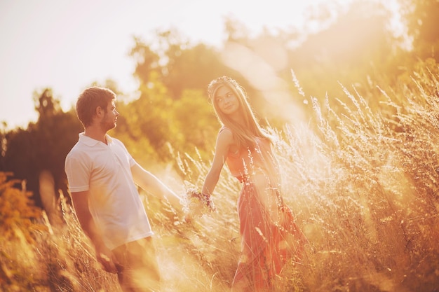 Paar liefhebbers knuffelen en zoenen in het park bij zonsondergang Love jeugd geluk concept