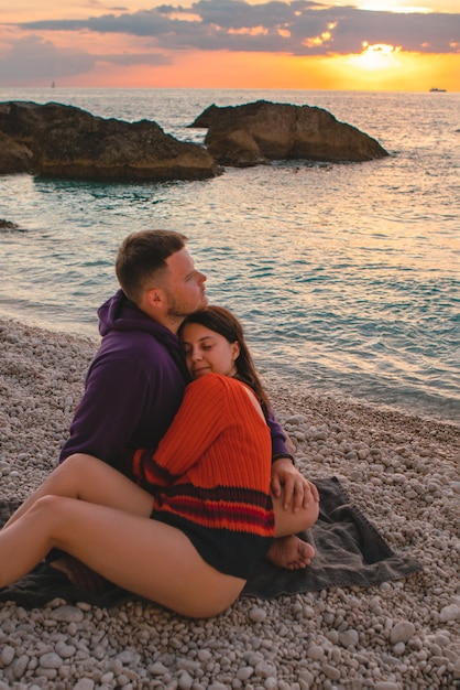 Paar liefhebbers op het strand genieten van tijd samen en zonsondergang boven de zee griekenland vakantie lefkada eiland