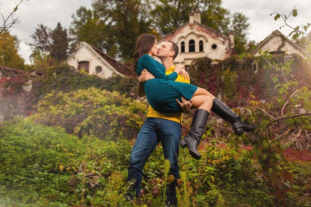 Paar man en vrouw poseren in de buurt van oud oud kasteel in herfstbos
