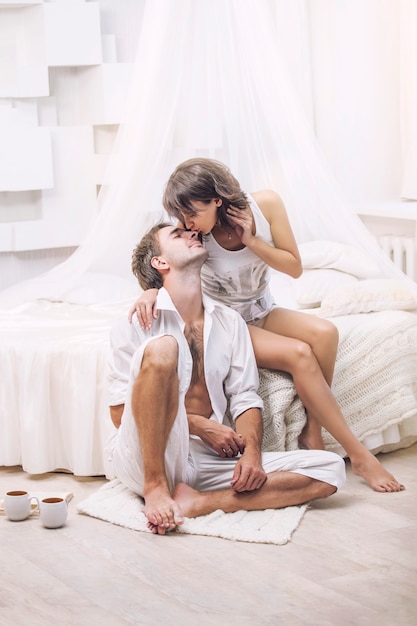 Paar man en vrouw thuis in bed met een kopje koffie. Tedere liefde in familierelaties