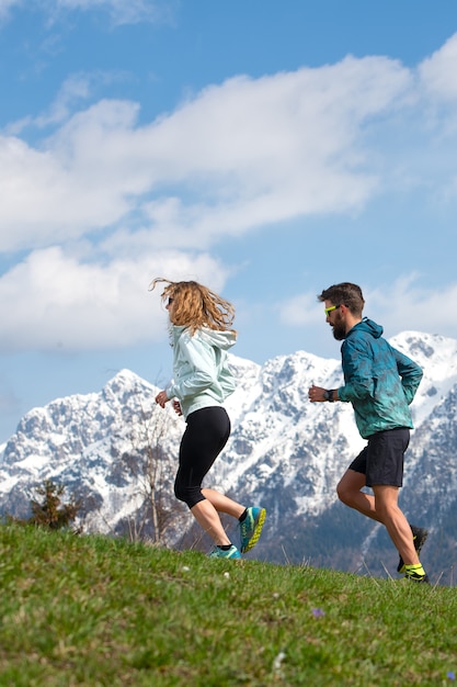 Paar mannelijke en vrouwelijke atleten trainen in de bergen