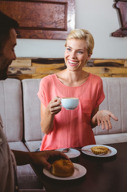 Foto paar met een koffiekopje zittend op de bank