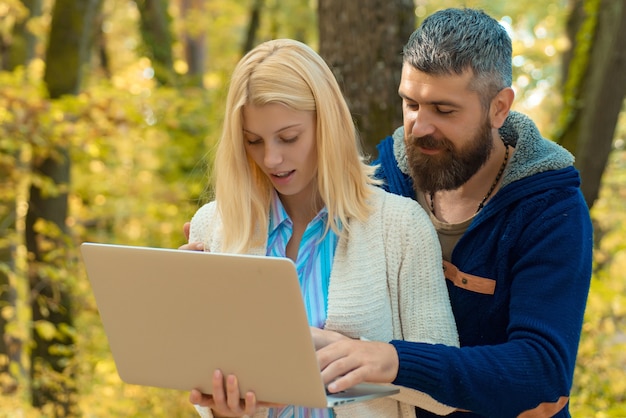 Paar met laptop buiten in de herfst