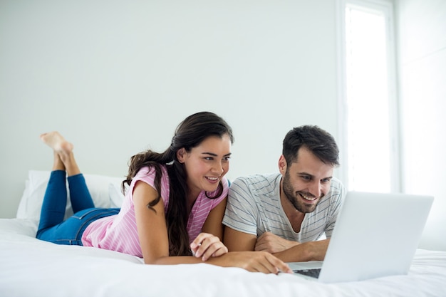 Paar met laptop in de slaapkamer thuis