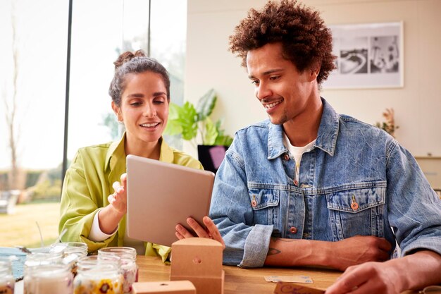 Paar met online bedrijf dat boetiekkaarsen maakt thuis kortingsbonnen en labels schrijven