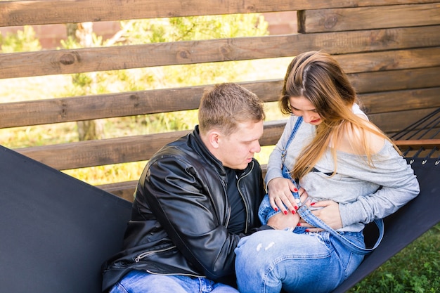 Paar met zwangere vrouw die samen op hangmat ontspant