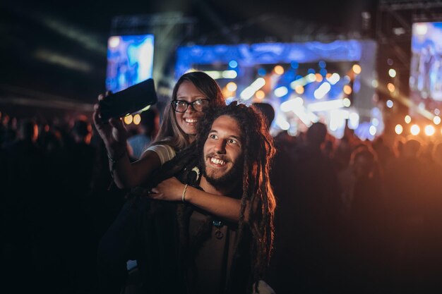 Paar nemen selfie met een smartphone op een muziekfestival